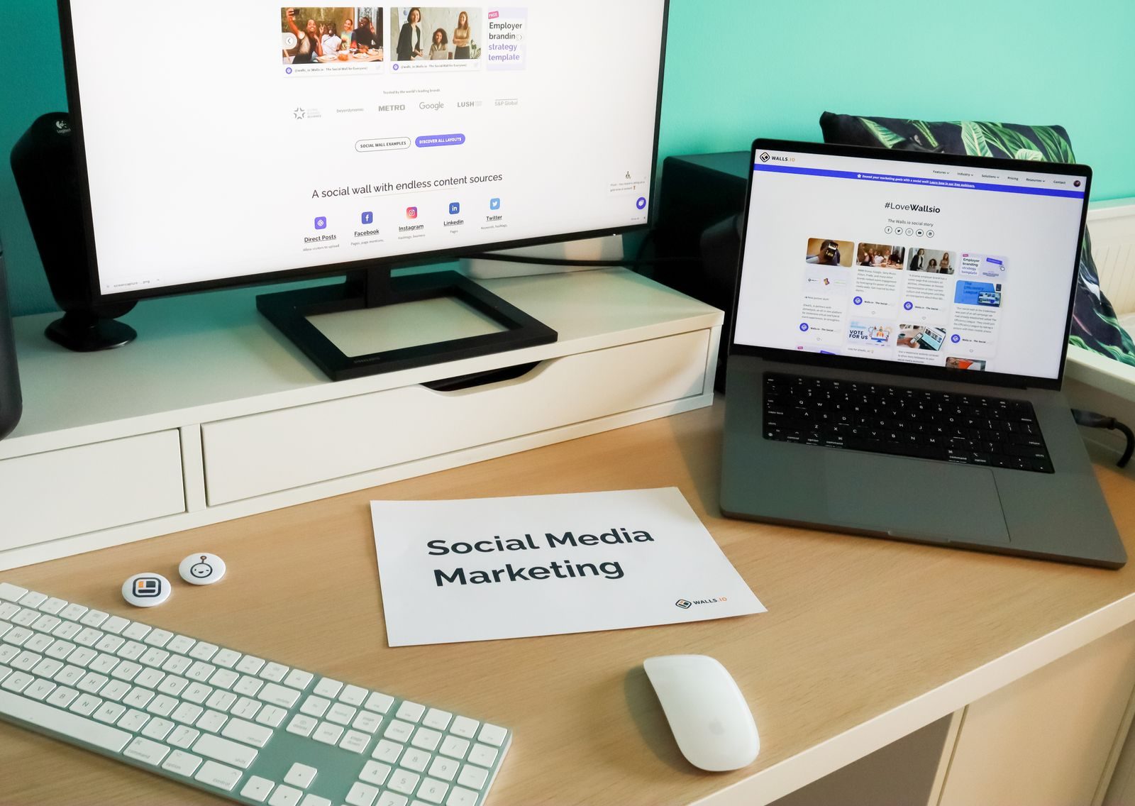 Desk with a monitor and laptop showing social media marketing work